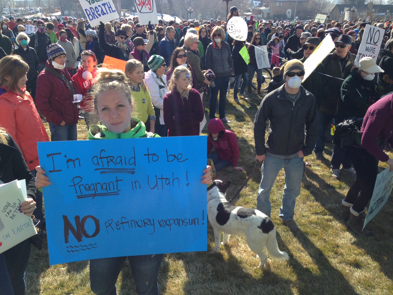 An attendee to the "Clean Air, No Excuses" rally holds her sign in the crowd.