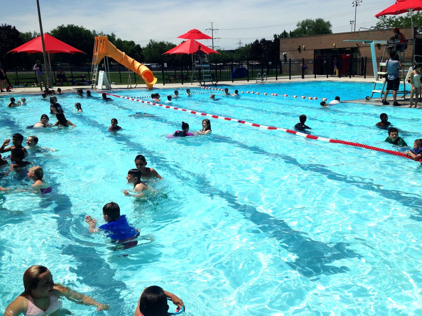Children enjoy the Redwood Recreation Center's outdoor pool on a hot summer day.