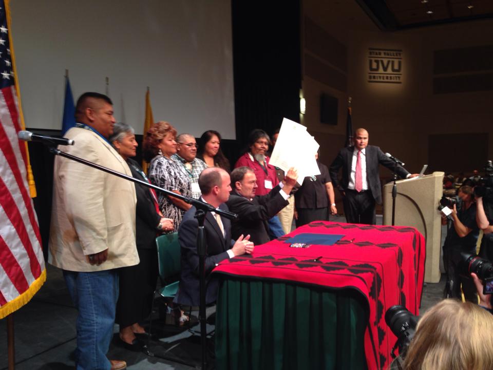 Utah Governor Gary Herbert, seated next to Lt. Governor Spencer Cox and surrounded by Utah tribal leaders, holds up an executive order he signed at the Governor's Native American Summit in Orem, Utah, on July 30, 2014.