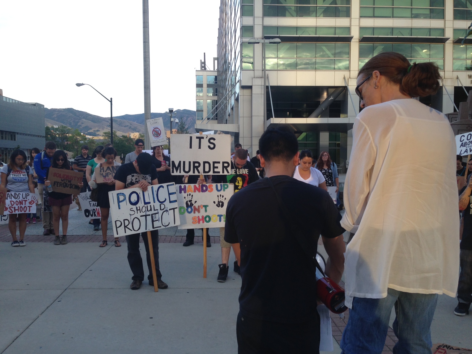 Protestors take a moment of silence during a protest against aggressive police tactics on August 20, 2014.